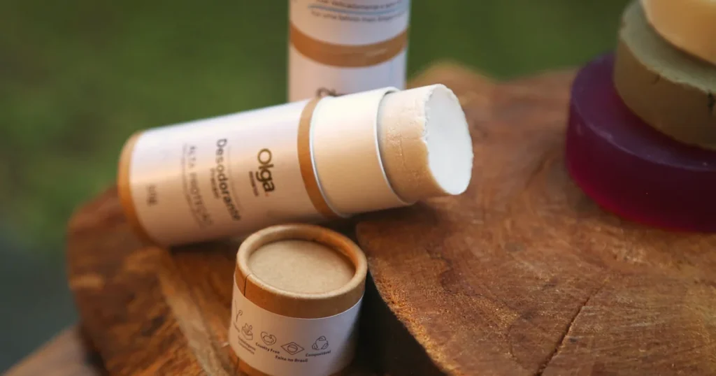Desodorante Pracaxi da Olga Biocosméticos aberto sobre madeira, com embalagem de papel kraft e selos cruelty-free e compostável
