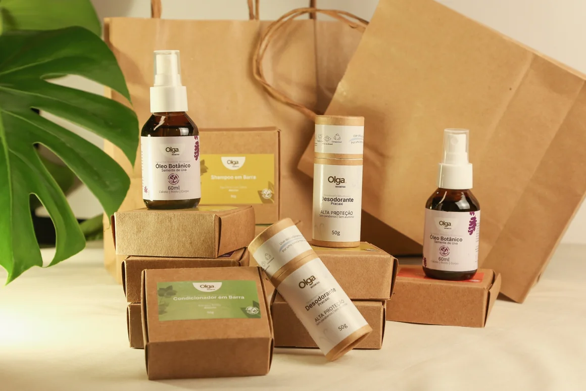 Cosméticos naturais e veganos da Olga Biocosméticos em embalagens de papel kraft compostável, com sacolas kraft e folha de costela-de-adão